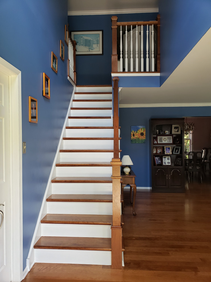 This is an example of a mid-sized eclectic wood straight staircase in Philadelphia with painted wood risers and wood railing.