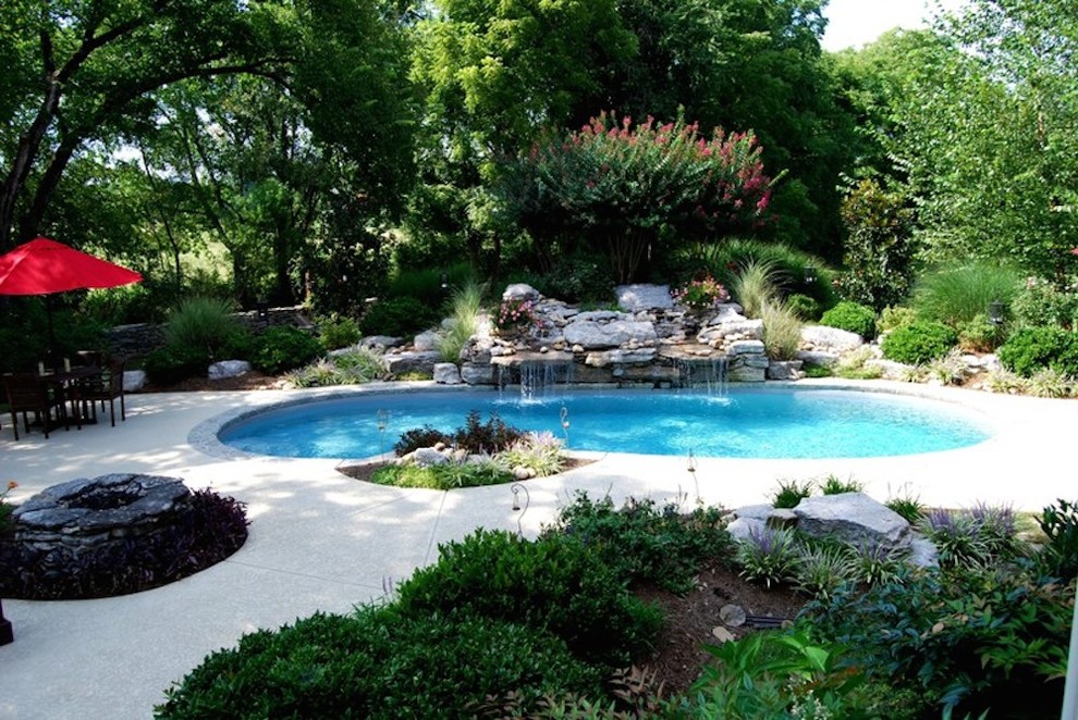 Example of a mid-sized transitional backyard concrete paver and custom-shaped pool design in Nashville