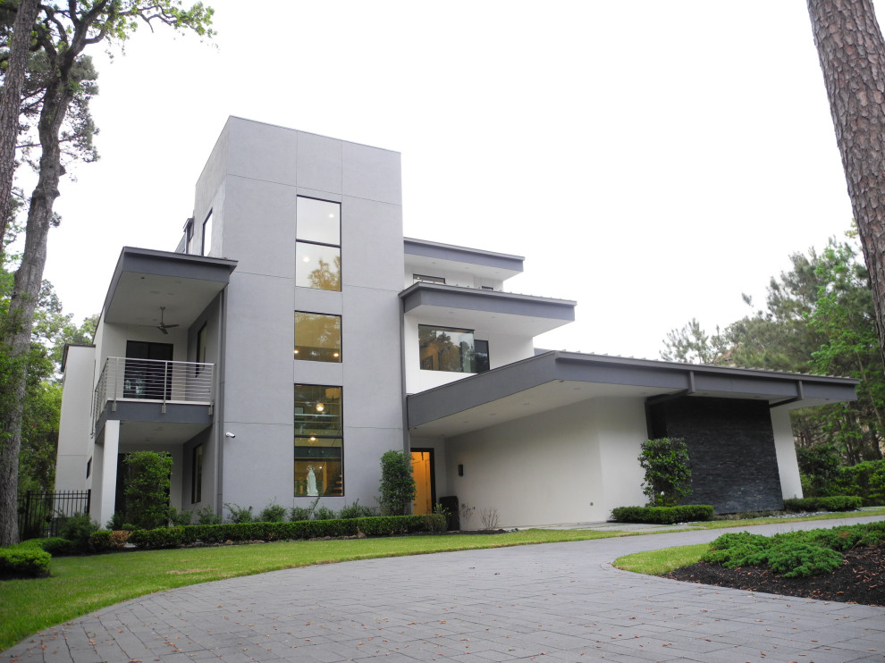 Стильный дизайн: огромный, трехэтажный, белый частный загородный дом в стиле модернизм с облицовкой из цементной штукатурки, плоской крышей, металлической крышей и белой крышей - последний тренд