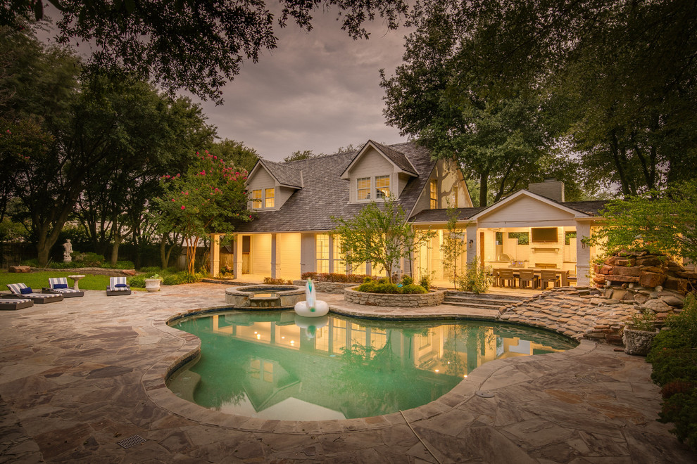 Photo of a transitional backyard custom-shaped pool in Dallas with a hot tub.