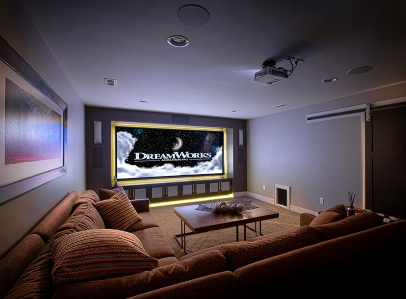 Photo of a mid-sized transitional enclosed home theatre in Other with grey walls, carpet, a projector screen and beige floor.