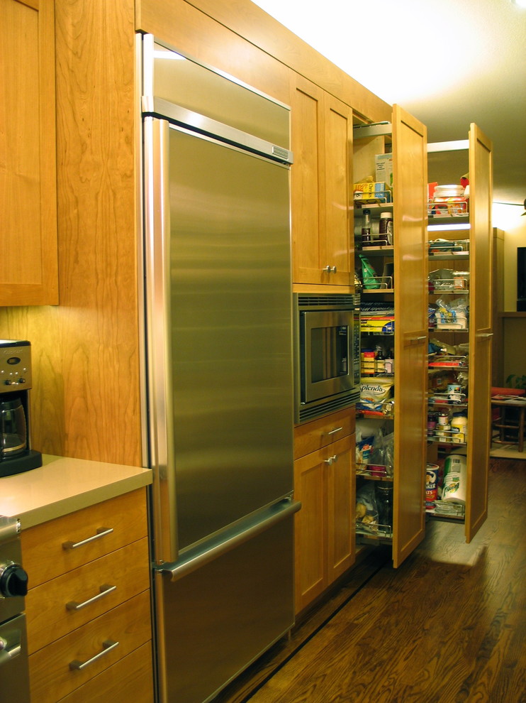 This is an example of a small contemporary u-shaped eat-in kitchen in San Francisco with an undermount sink, flat-panel cabinets, medium wood cabinets, stainless steel appliances, dark hardwood floors, no island and brown floor.