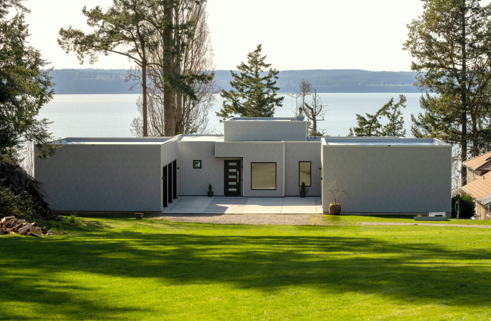 Imagen de fachada de casa blanca y blanca moderna de tamaño medio de dos plantas con revestimiento de aglomerado de cemento y tejado plano