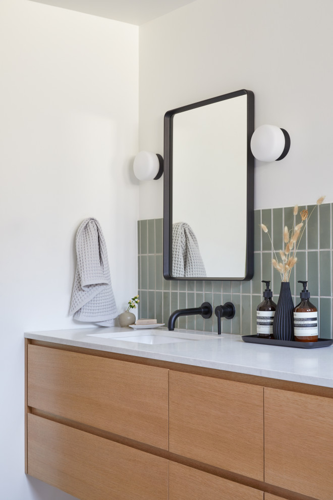 This is an example of a small midcentury kids bathroom in San Francisco with flat-panel cabinets, brown cabinets, an alcove tub, green tile, ceramic tile, white walls, ceramic floors, an undermount sink, engineered quartz benchtops, white floor, a hinged shower door, white benchtops, a niche, a double vanity and a floating vanity.