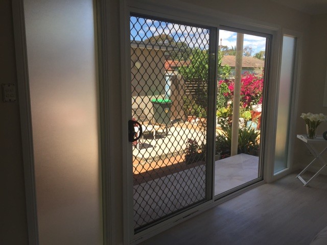 Photo of a large beach style master bedroom in Sydney with beige walls, vinyl floors and white floor.