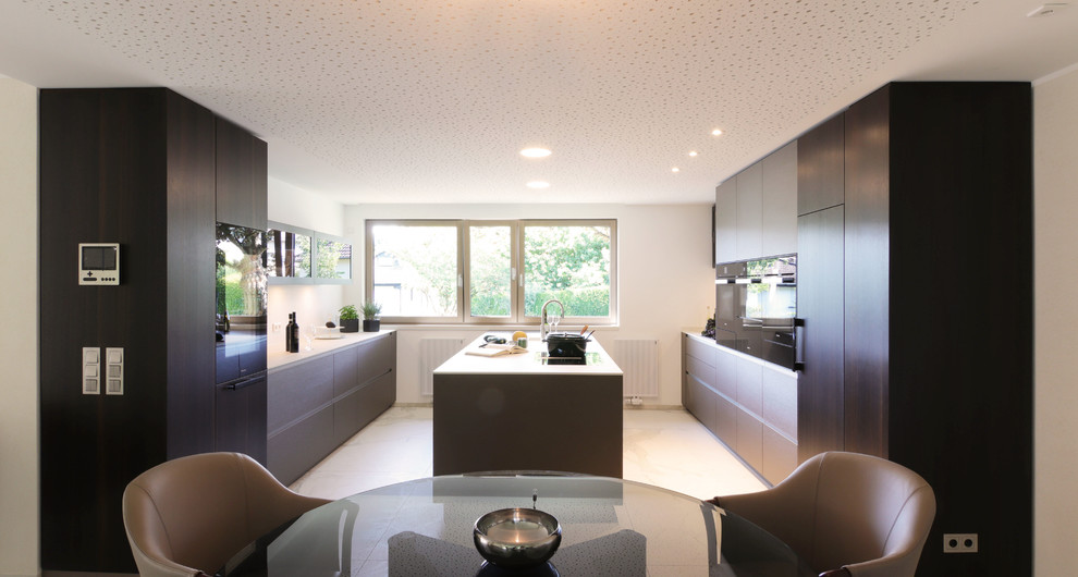 Large contemporary galley open plan kitchen in Frankfurt with an integrated sink, flat-panel cabinets, green cabinets, tile benchtops, white splashback, stainless steel appliances, marble floors, with island, white floor and white benchtop.