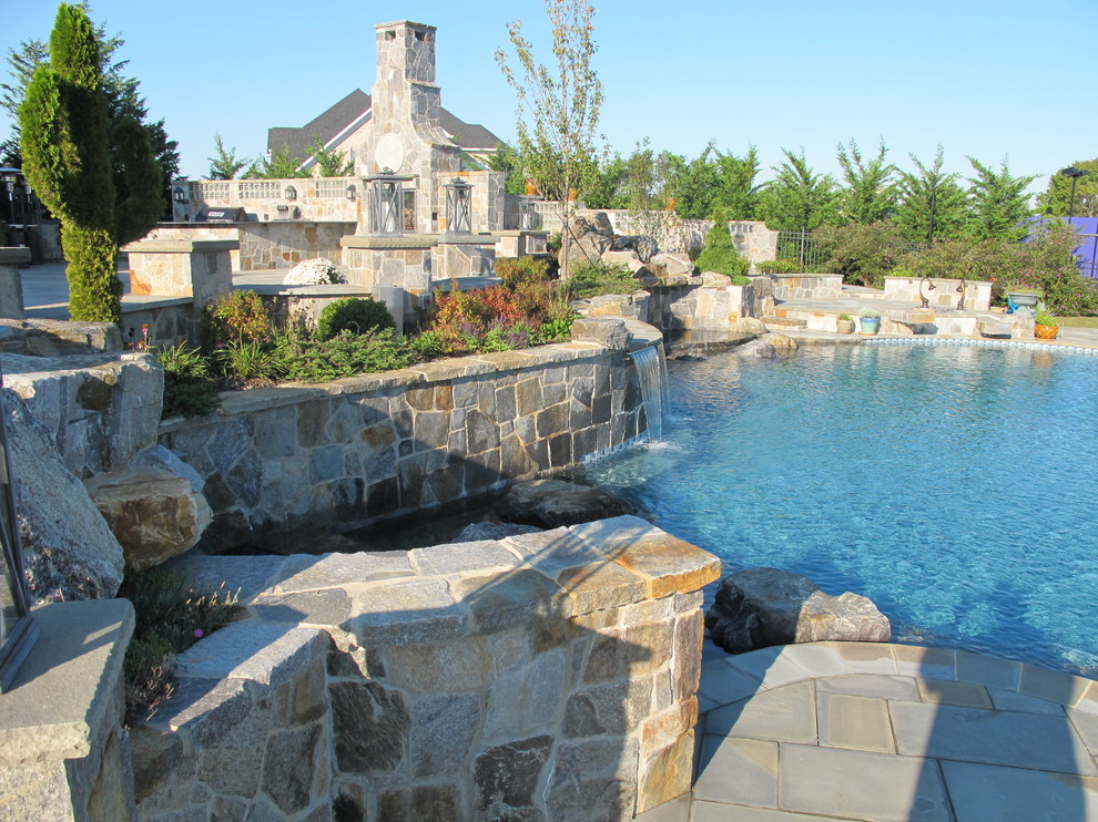 Design ideas for a large traditional backyard custom-shaped natural pool in Baltimore with a water feature and concrete pavers.