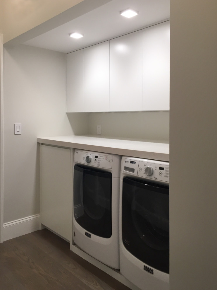 Small transitional single-wall utility room in New York with flat-panel cabinets, white cabinets, quartz benchtops, dark hardwood floors, a side-by-side washer and dryer and yellow benchtop.