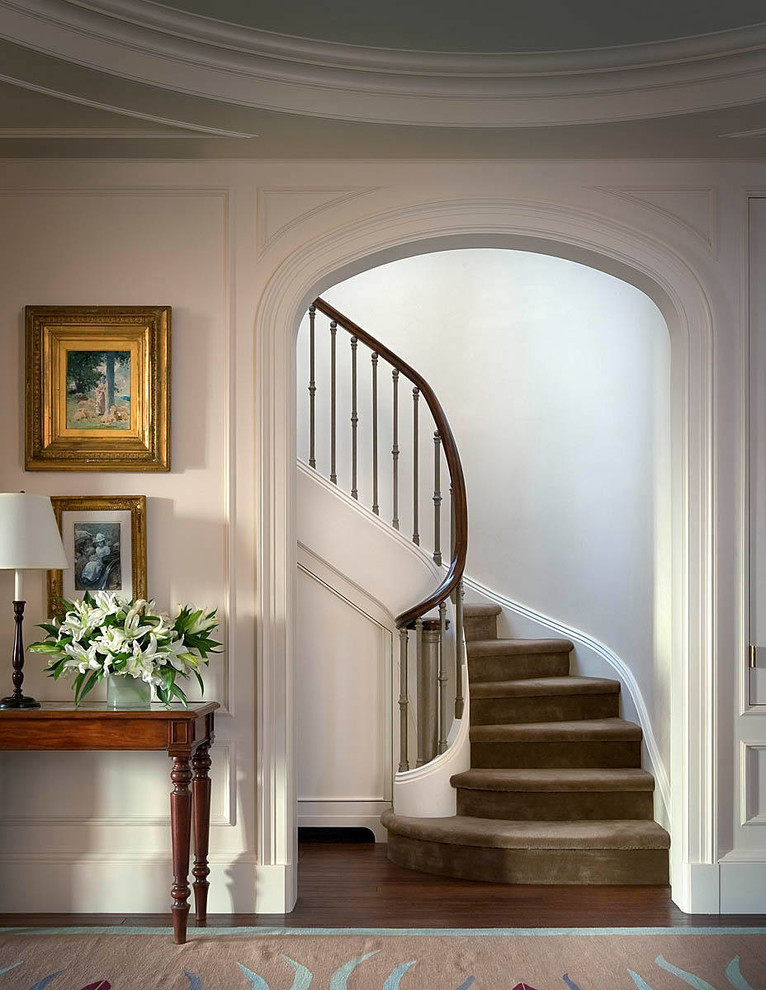 This is an example of a mid-sized traditional carpeted curved staircase in New York with carpet risers.
