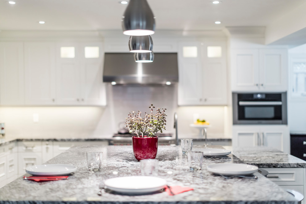 Example of a mid-sized transitional brown floor kitchen design in Toronto with white cabinets, stainless steel appliances and an island