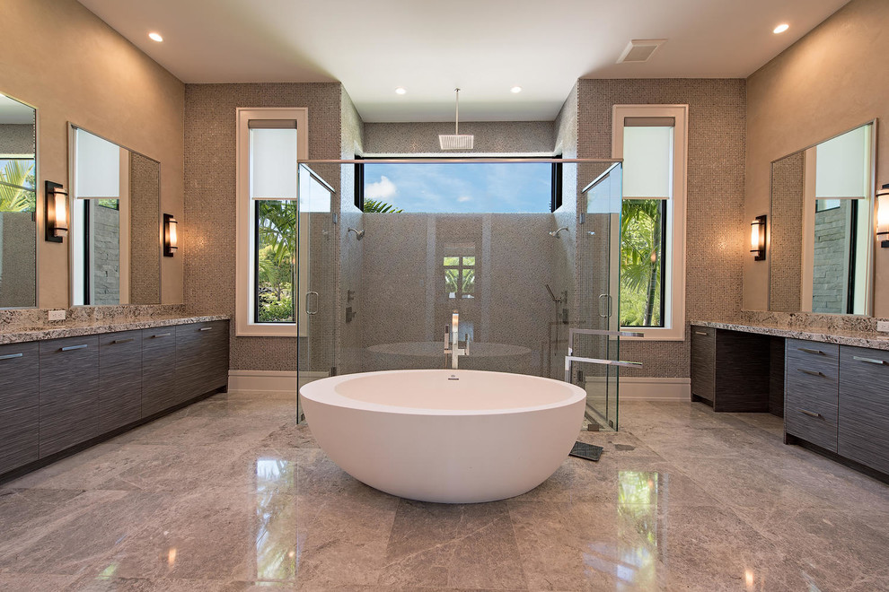Photo of a large contemporary master bathroom in Other with flat-panel cabinets, a freestanding tub, an alcove shower, beige tile, glass tile, beige walls, ceramic floors, granite benchtops, beige floor and a hinged shower door.