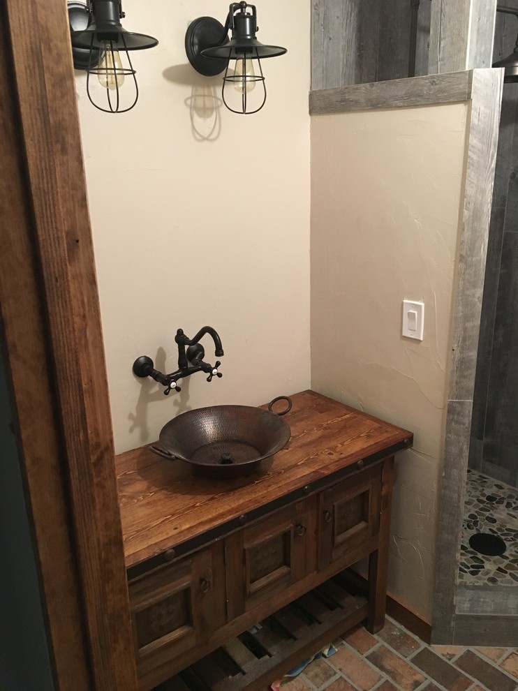 This is an example of a country 3/4 bathroom in Other with recessed-panel cabinets, dark wood cabinets, a corner shower, brick floors, a vessel sink, wood benchtops and a shower curtain.