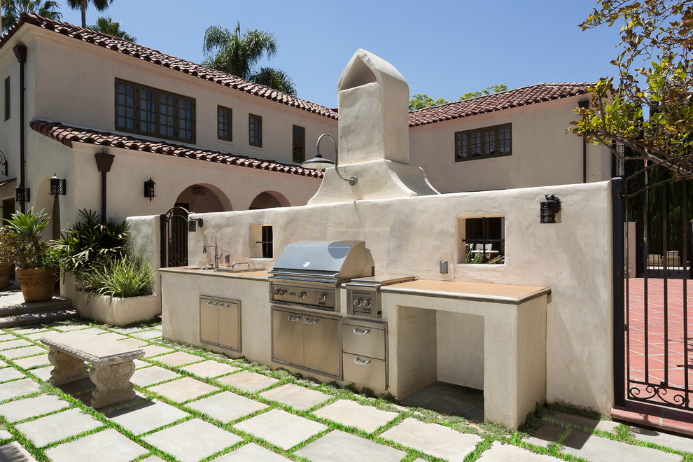 Photo of a large mediterranean courtyard patio in Los Angeles with a fire feature, tile and no cover.