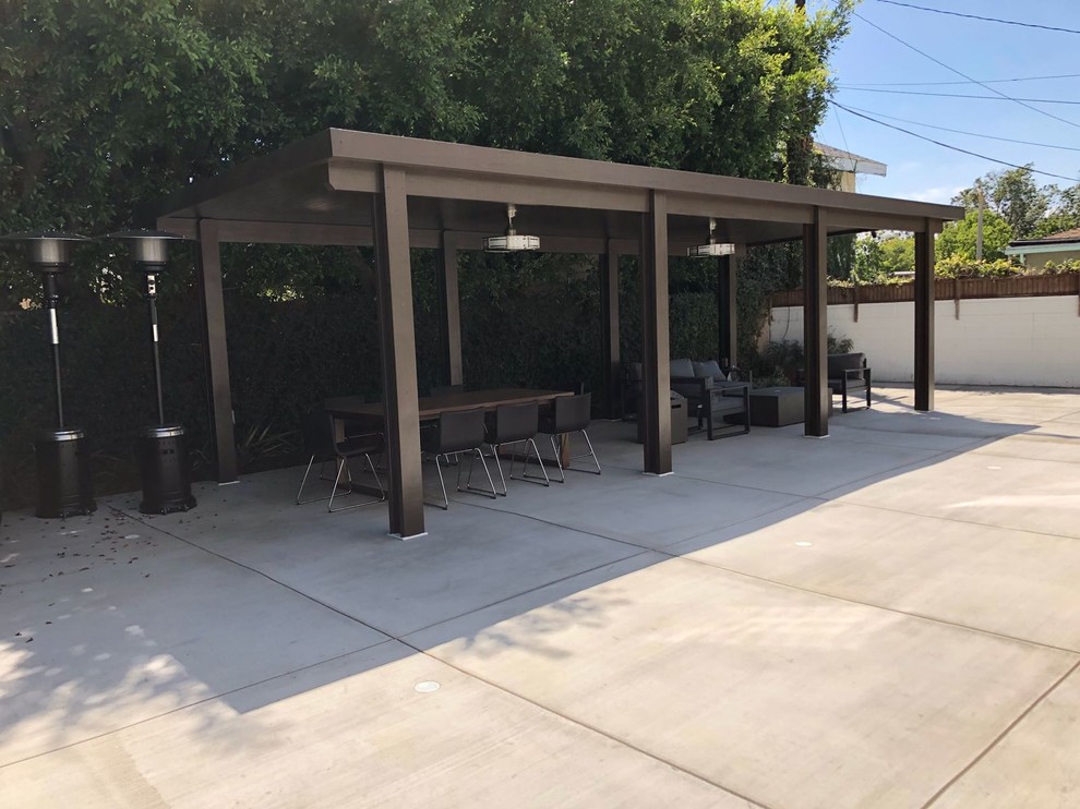 Photo of a large transitional backyard patio in Los Angeles with an outdoor kitchen, concrete slab and a pergola.