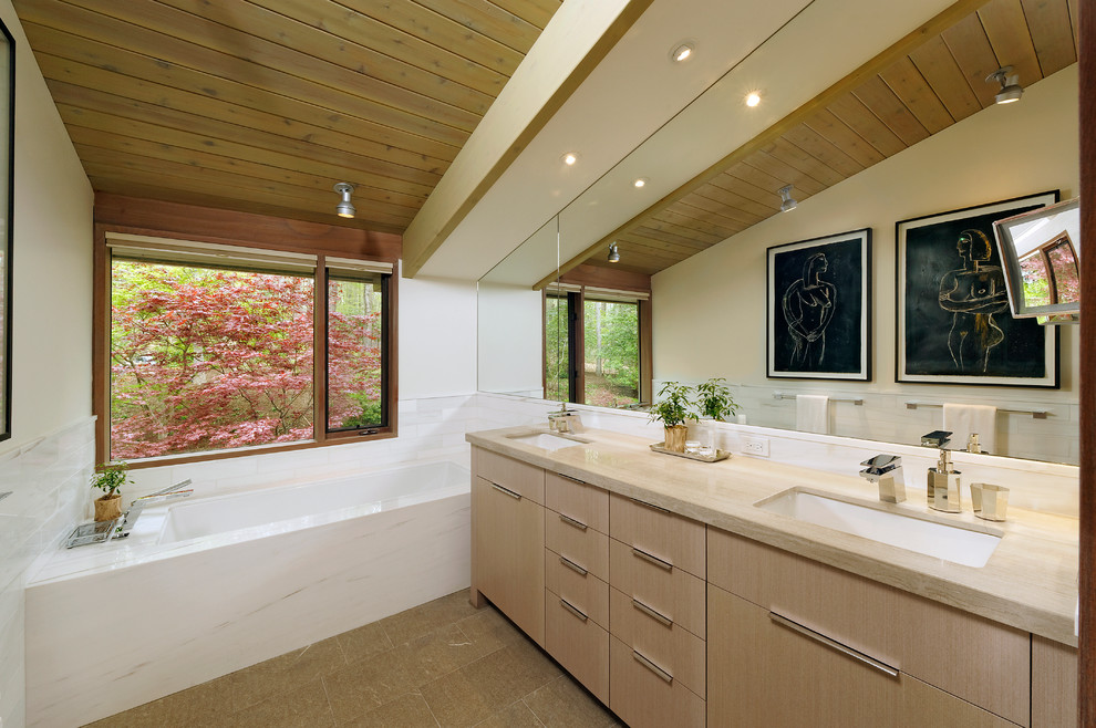 Photo of a mid-sized contemporary master bathroom in DC Metro with flat-panel cabinets, light wood cabinets, an undermount tub, a corner shower, a one-piece toilet, white tile, white walls, an undermount sink, wood benchtops, porcelain tile and concrete floors.