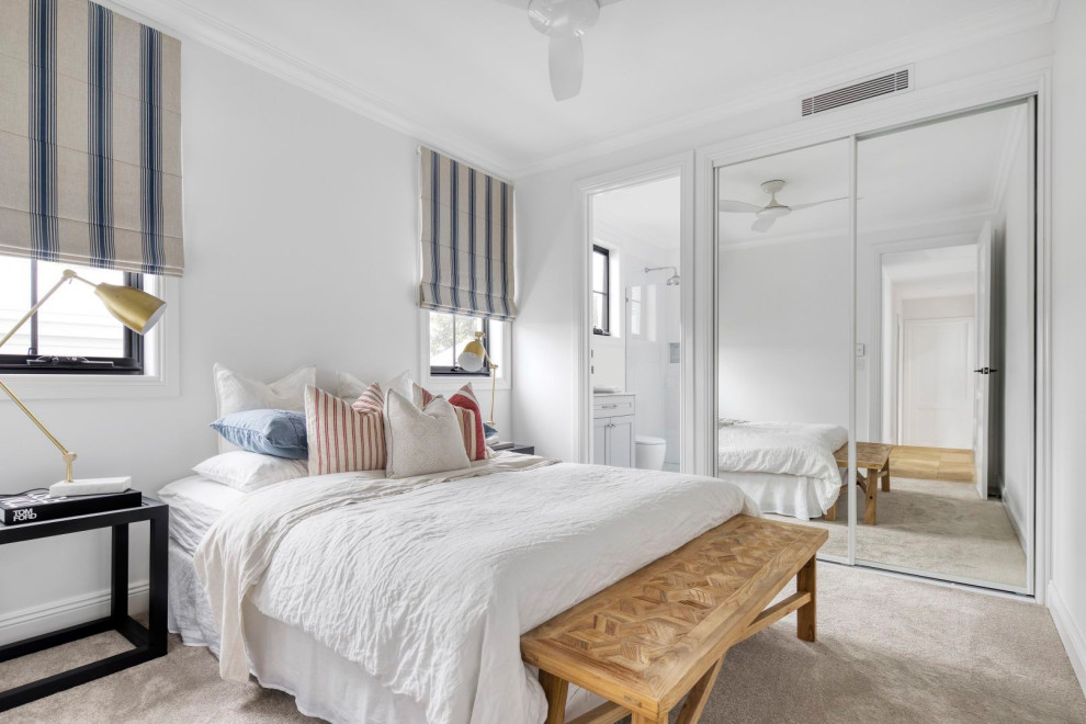 Immagine di una camera da letto design con pareti bianche, moquette e pavimento beige