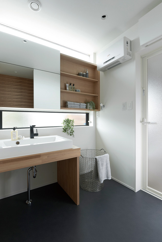 Idéer för att renovera ett mellanstort minimalistiskt vit vitt toalett, med öppna hyllor, bruna skåp, vita väggar, vinylgolv, träbänkskiva och svart golv