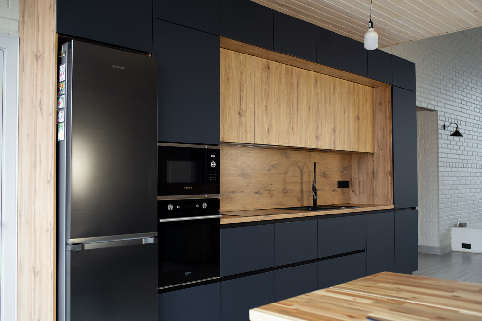 Large industrial single-wall eat-in kitchen in Other with an undermount sink, flat-panel cabinets, black cabinets, laminate benchtops, brown splashback, black appliances, laminate floors, with island, beige floor, brown benchtop and timber.