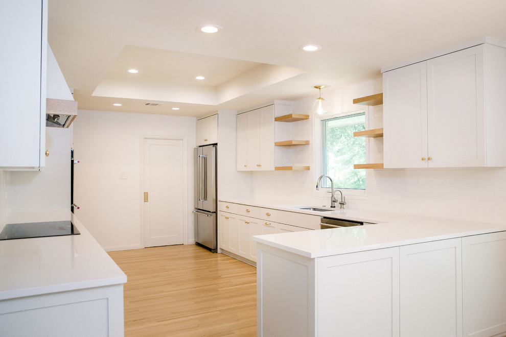 Eat-in kitchen - large transitional u-shaped light wood floor and brown floor eat-in kitchen idea in Austin with an undermount sink, shaker cabinets, white cabinets, quartzite countertops, white backsplash, ceramic backsplash, stainless steel appliances, no island and white countertops