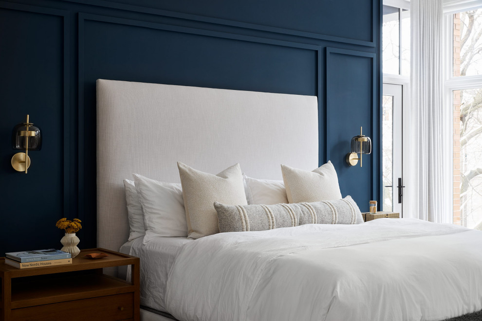 Foto di una camera matrimoniale moderna con pareti blu, parquet chiaro e pannellatura
