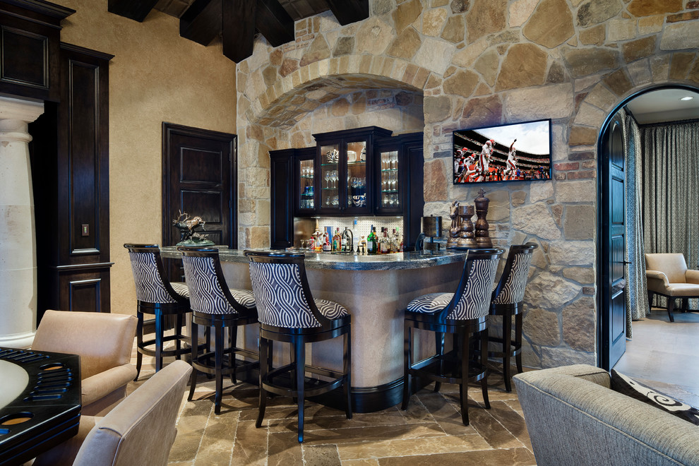 Photo of a mediterranean l-shaped seated home bar in Houston with glass-front cabinets and dark wood cabinets.