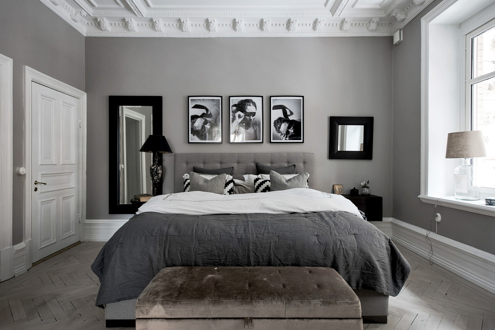Inspiration for a mid-sized transitional bedroom in Gothenburg with grey walls, light hardwood floors and grey floor.