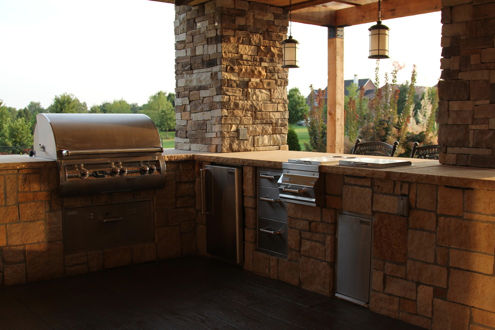 Inspiration for a large contemporary backyard patio in Kansas City with an outdoor kitchen, stamped concrete and a roof extension.