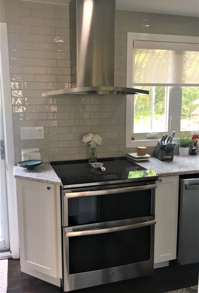 Eat-in kitchen - small transitional u-shaped dark wood floor and brown floor eat-in kitchen idea in Boston with an undermount sink, shaker cabinets, white cabinets, quartz countertops, gray backsplash, subway tile backsplash, stainless steel appliances and gray countertops
