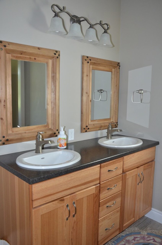Mid-sized mountain style master vinyl floor home design photo in Toronto with shaker cabinets, light wood cabinets, a drop-in sink and laminate countertops