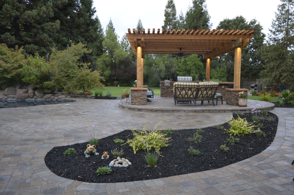 Inspiration for a mid-sized traditional backyard patio in Sacramento with concrete pavers, an outdoor kitchen and a pergola.