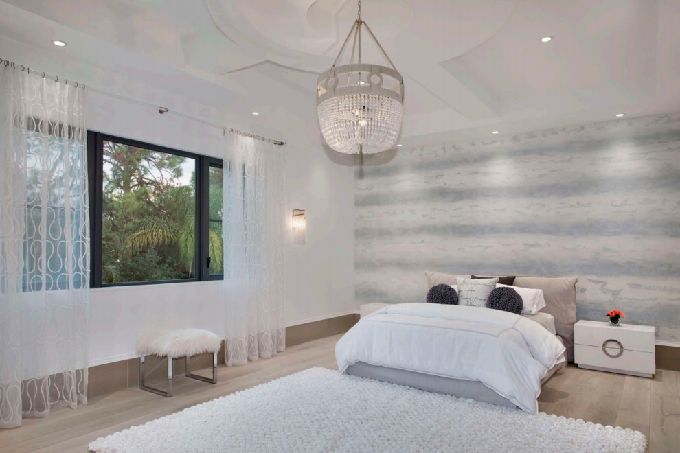 Large contemporary guest bedroom in New York with white walls, light hardwood floors and beige floor.