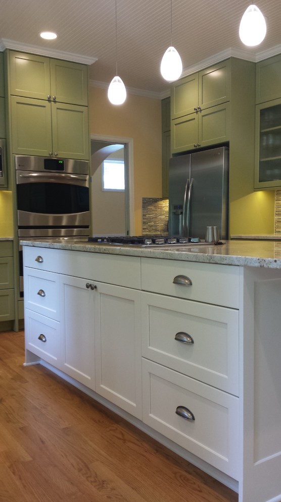 Kitchen - large transitional u-shaped medium tone wood floor kitchen idea in Seattle with a double-bowl sink, recessed-panel cabinets, white cabinets, granite countertops, multicolored backsplash, mosaic tile backsplash, stainless steel appliances and an island