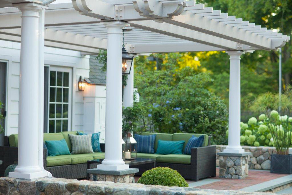 Design ideas for a mid-sized traditional backyard patio in New York with brick pavers and a pergola.