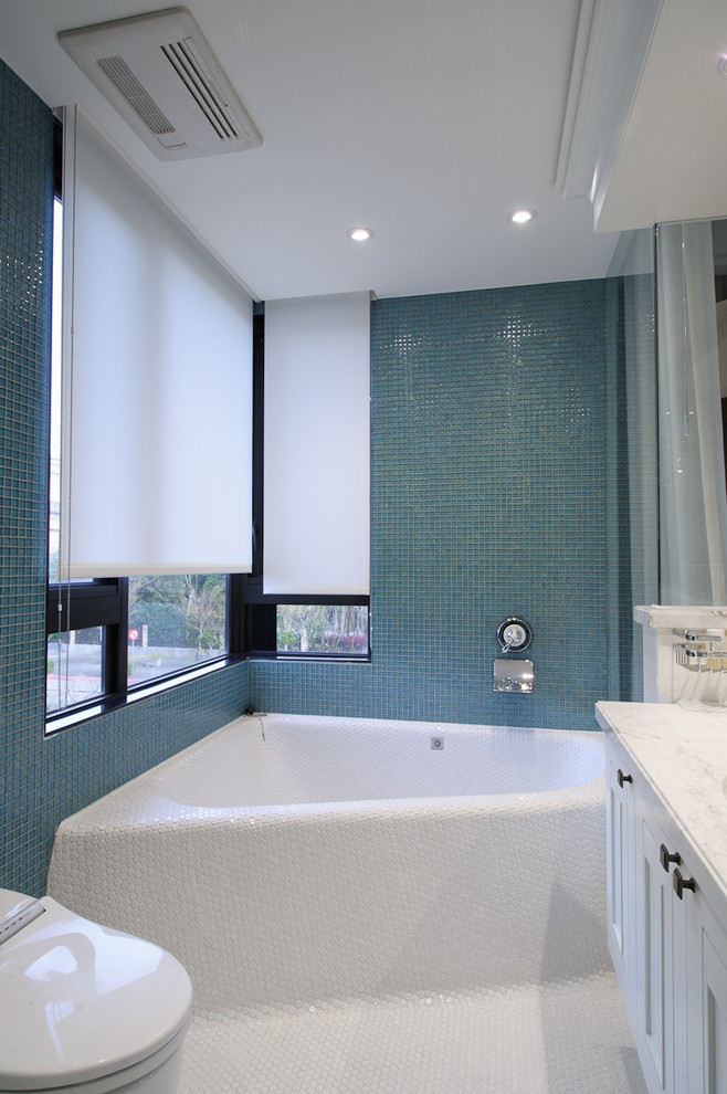 Design ideas for a contemporary bathroom in New York with a corner tub and mosaic tile.