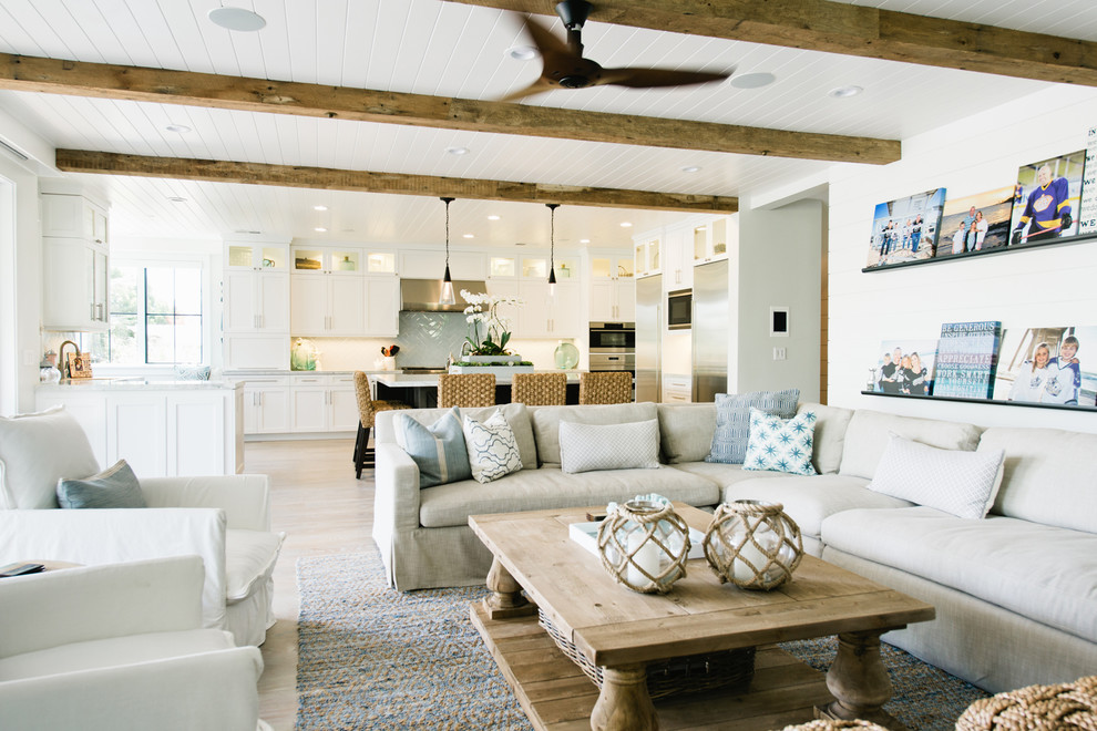 Large beach style family room in Los Angeles with white walls, light hardwood floors and a wall-mounted tv.