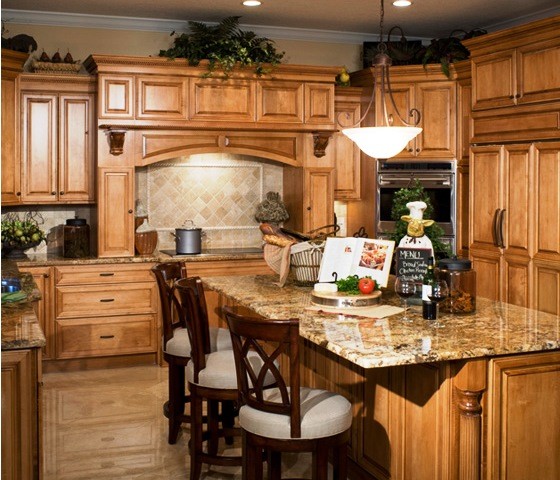 This is an example of a traditional eat-in kitchen in Tampa with raised-panel cabinets, light wood cabinets, granite benchtops, beige splashback, ceramic splashback, stainless steel appliances, ceramic floors and with island.