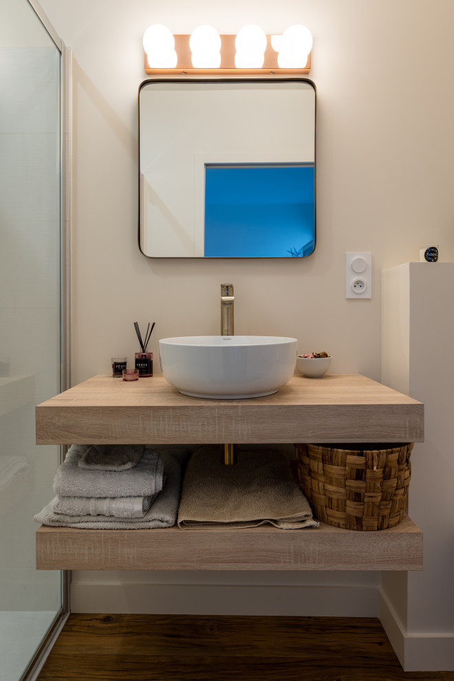 Exempel på ett litet eklektiskt badrum med dusch, med öppna hyllor, en dusch i en alkov, en vägghängd toalettstol, vit kakel, keramikplattor, beige väggar, laminatgolv, ett nedsänkt handfat, laminatbänkskiva och dusch med skjutdörr