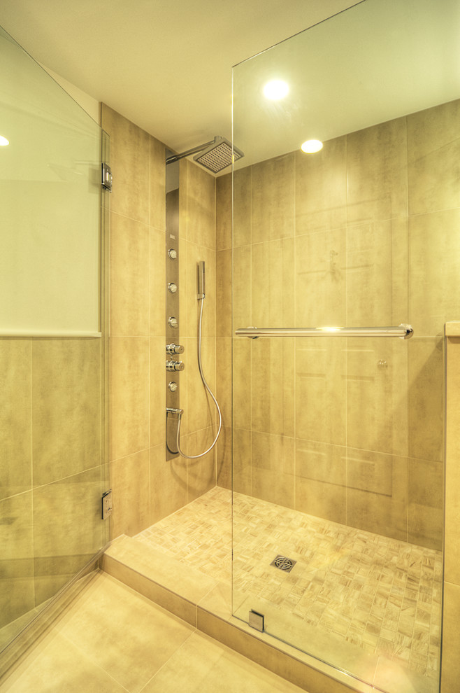 Photo of a mid-sized contemporary 3/4 bathroom with an undermount sink, flat-panel cabinets, light wood cabinets, engineered quartz benchtops, an alcove shower, a wall-mount toilet, beige tile, porcelain tile, beige walls and travertine floors.