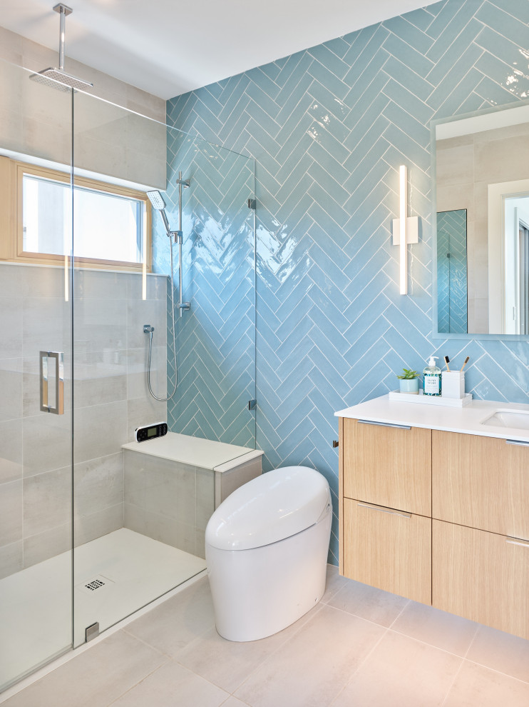 Photo of a mid-sized contemporary master bathroom in Vancouver with flat-panel cabinets, light wood cabinets, an alcove shower, a one-piece toilet, blue tile, ceramic tile, white walls, porcelain floors, an undermount sink, engineered quartz benchtops, grey floor, a hinged shower door, white benchtops, a shower seat, a single vanity and a floating vanity.