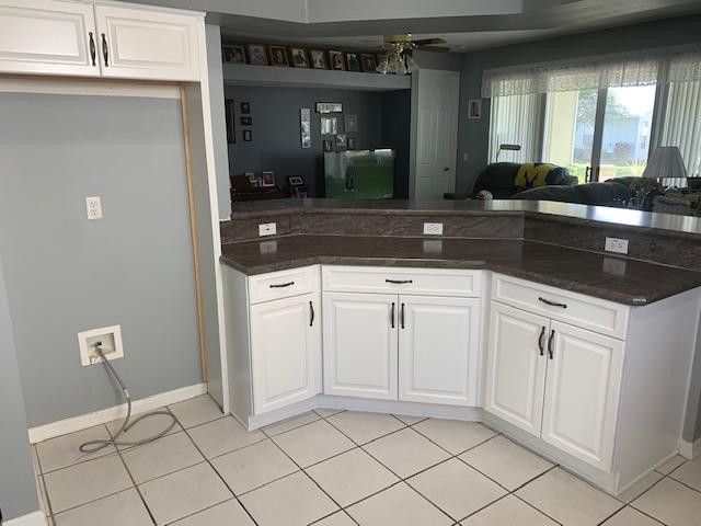 Inspiration for a mid-sized u-shaped eat-in kitchen remodel with an undermount sink, raised-panel cabinets, white cabinets, laminate countertops, a peninsula and black countertops