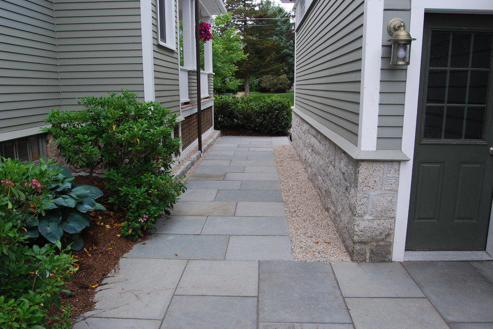 Large traditional courtyard patio in Boston with natural stone pavers.