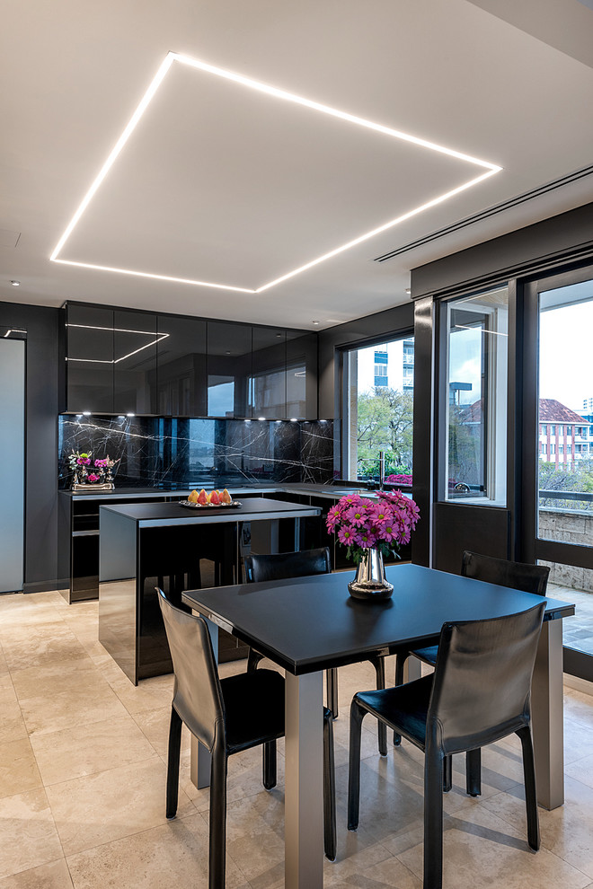 This is an example of a contemporary l-shaped eat-in kitchen in Perth with flat-panel cabinets, black cabinets, black splashback, black appliances, with island, beige floor and black benchtop.