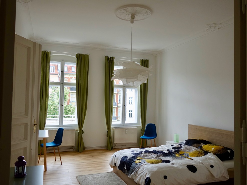 Hauptschlafzimmer ohne Kamin With weißer Wandfarbe, braunem Holzboden and braunem Boden in Berlin