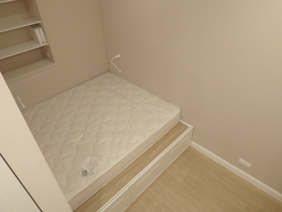 Foto de dormitorio principal actual pequeño sin chimenea con paredes beige, suelo laminado y suelo beige
