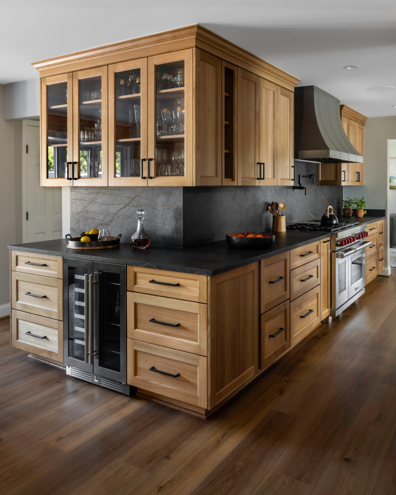 Large mountain style galley medium tone wood floor enclosed kitchen photo in DC Metro with recessed-panel cabinets, medium tone wood cabinets, quartz countertops, black backsplash, quartz backsplash, stainless steel appliances, no island and black countertops