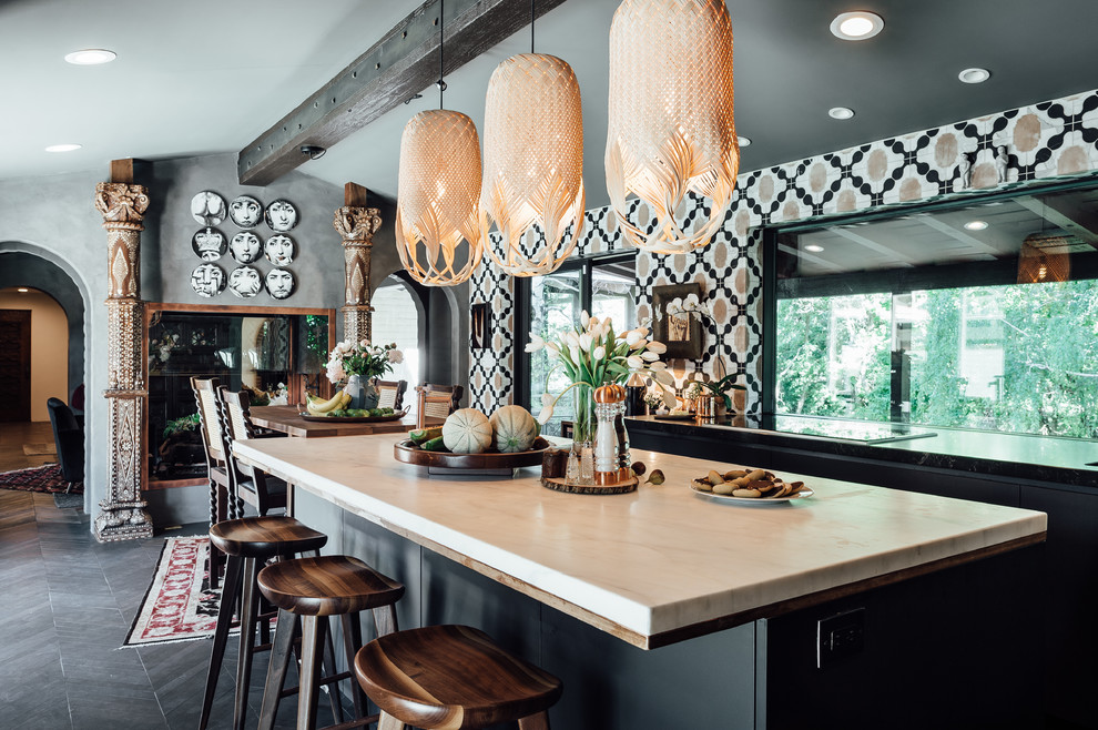 Inspiration for a mid-sized eclectic u-shaped eat-in kitchen in Salt Lake City with a drop-in sink, flat-panel cabinets, black cabinets, marble benchtops, multi-coloured splashback, stone tile splashback, panelled appliances, dark hardwood floors and multiple islands.