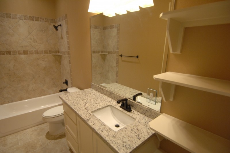Inspiration for a mid-sized rustic master beige tile and stone tile travertine floor and beige floor alcove bathtub remodel with raised-panel cabinets, white cabinets, beige walls, an undermount sink, granite countertops and a two-piece toilet