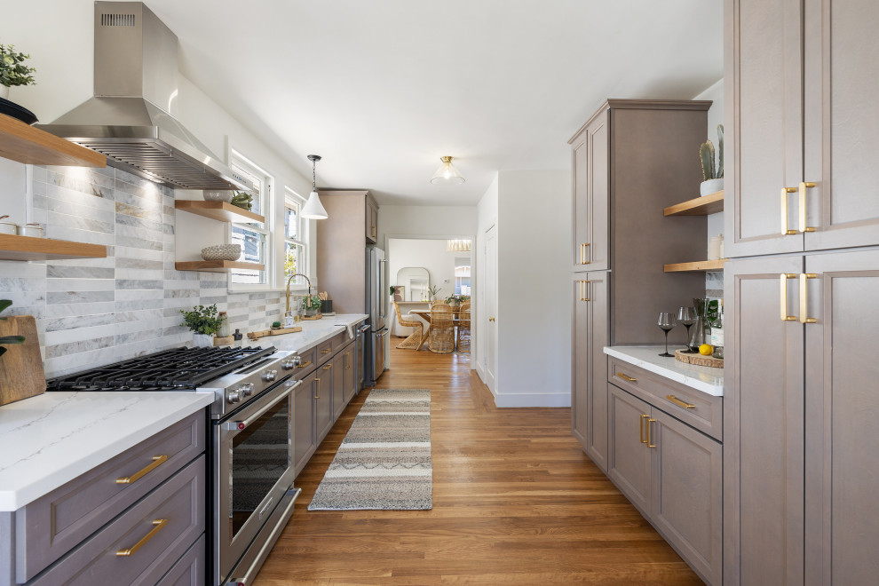 Photo of a mid-sized transitional galley separate kitchen in San Francisco with an undermount sink, recessed-panel cabinets, beige cabinets, quartz benchtops, beige splashback, marble splashback, stainless steel appliances, light hardwood floors, no island, beige floor and white benchtop.