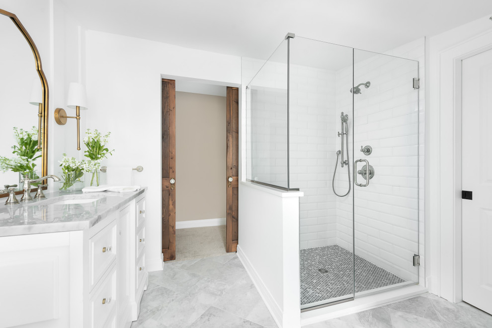 Design ideas for a mid-sized traditional master bathroom in Chicago with recessed-panel cabinets, white cabinets, a curbless shower, a two-piece toilet, white tile, subway tile, white walls, marble floors, an undermount sink, marble benchtops, white floor, a hinged shower door and white benchtops.