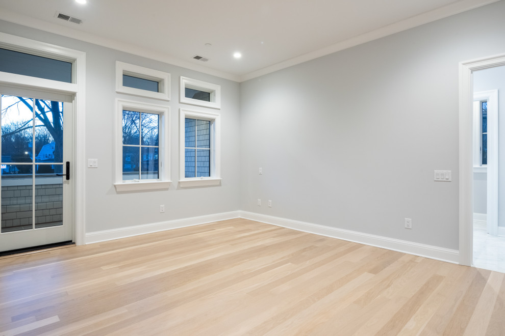 Ejemplo de dormitorio clásico renovado de tamaño medio con paredes azules, suelo de madera clara y bandeja